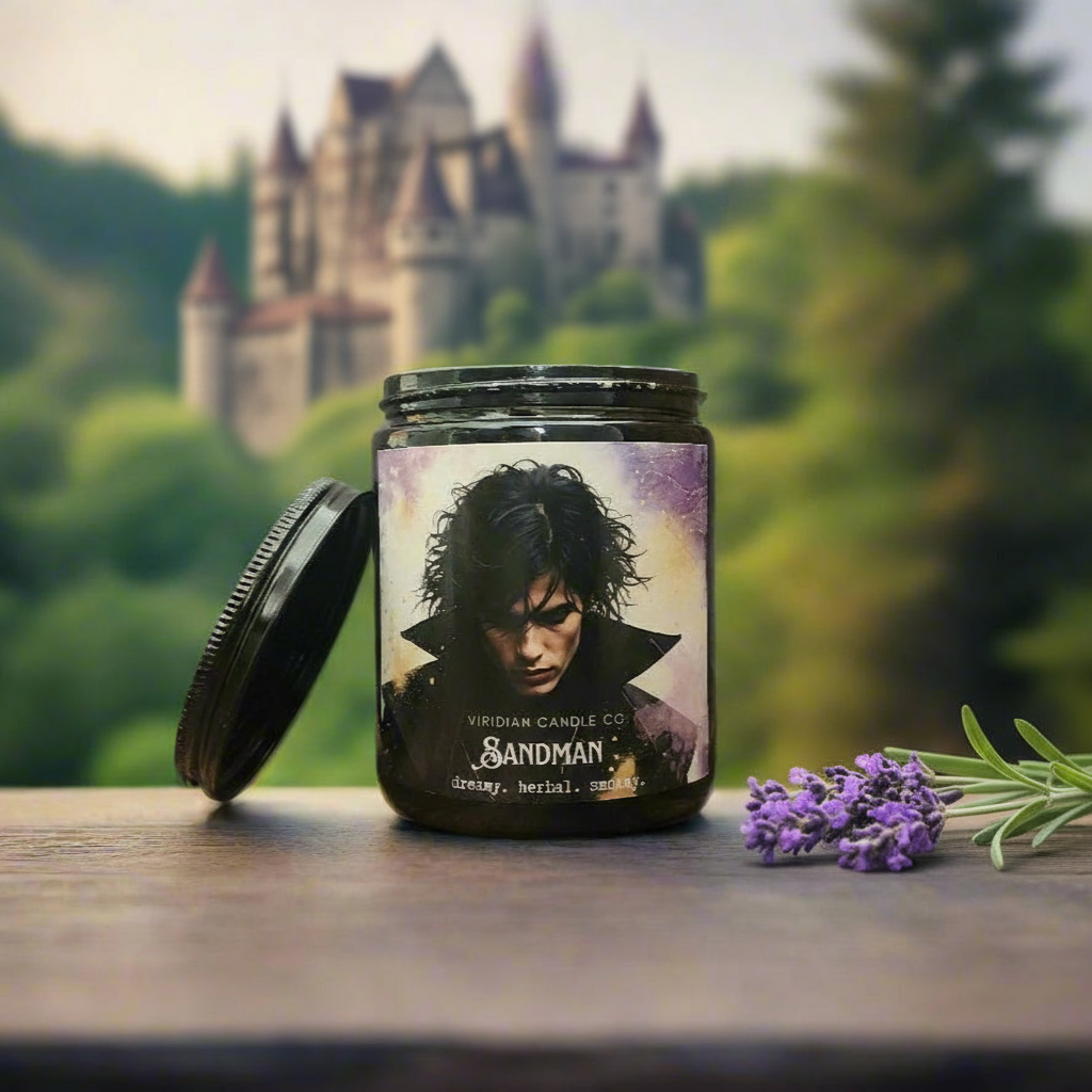 Sandman Fantasy soy candle by Viridian Candle Co., on a table with a sprig of lavender blooms and a castle in the background.