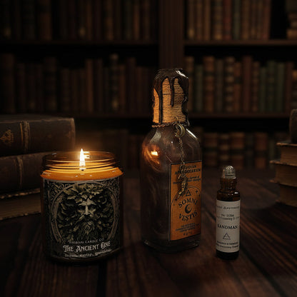 Alchemist’s Ritual dark academia bundle featuring Ancient One soy candle, Somnivestis potion bottle, and Sandman fragrance essence on a dark wooden surface.