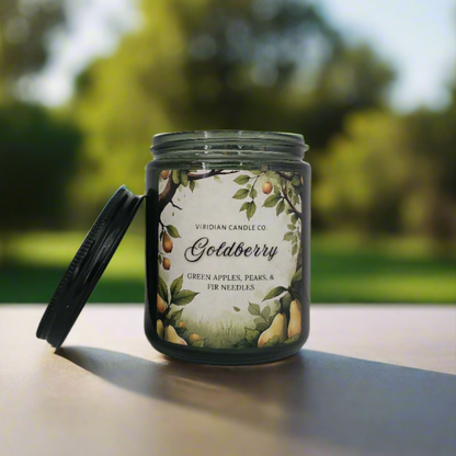 Viridian Crafts 'Goldberry' artisan fantasy candle on a blurred orchard in the background. Tolkien inspired fantasy candle handcrafted in Johannesburg