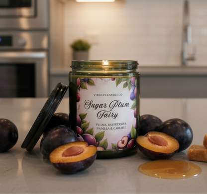 Viridian Candle Co. 'Sugar Plum Fairy' candle on a kitchen counter with plums and honey.