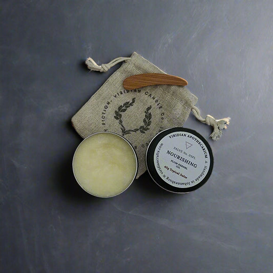 Viridian Apothecarium's Nourishing Salve tin opened, and wooden spatula on a textured gray surface with a branded burlap drawstring bag.